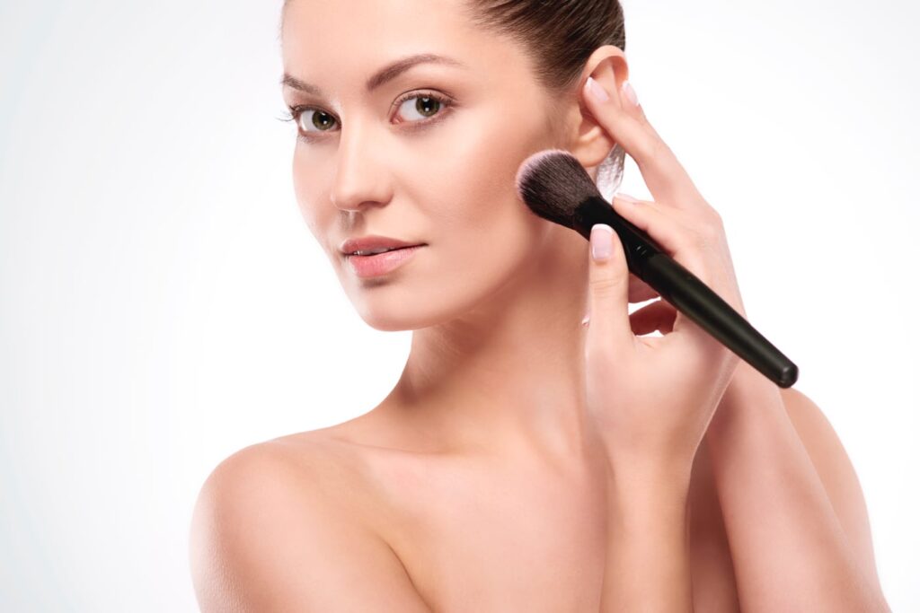 Modelo aplicando maquillaje facial
